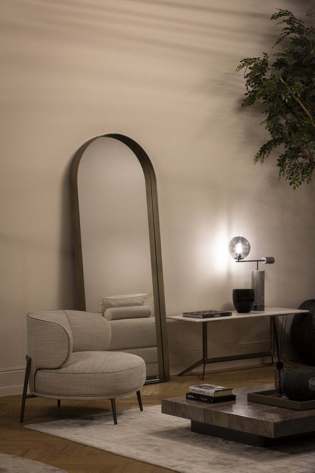Fauteuil Ricardo in taupe met contrasterende bies bij een hoge spiegel en console.
